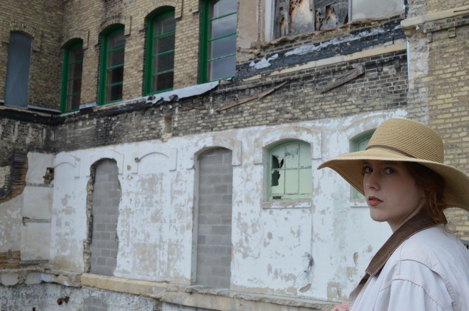 Soft portrait in a straw hat in an industrial courtyard