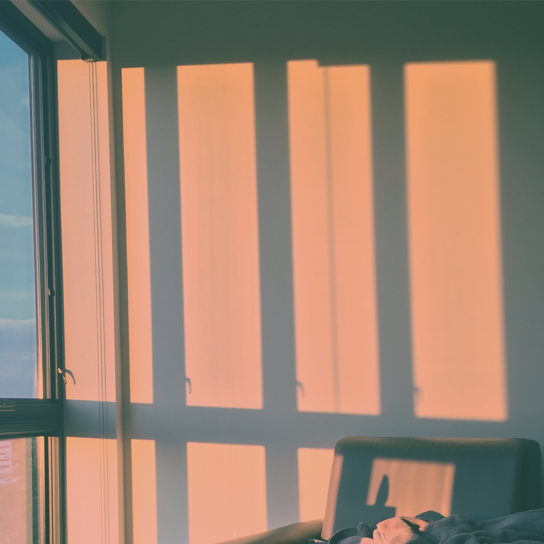 Warm rectangular window shadows falling across a pale interior wall